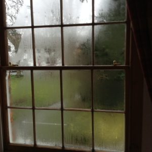 Condensation on dark wooden framed window